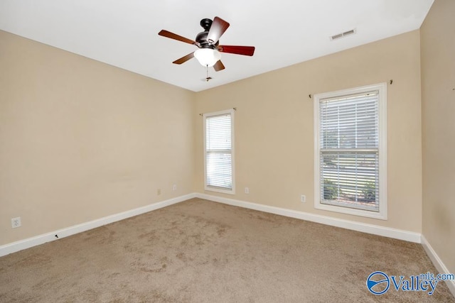 carpeted spare room featuring ceiling fan