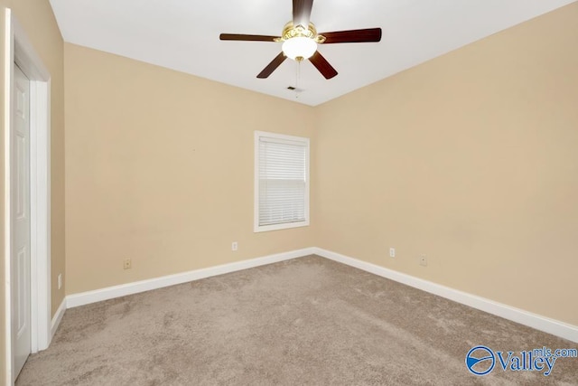 carpeted spare room featuring ceiling fan