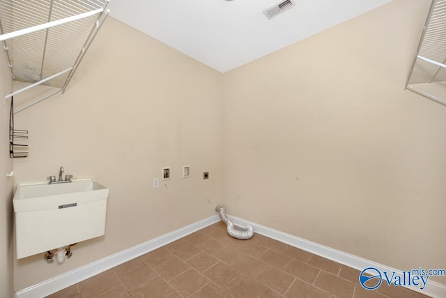 clothes washing area featuring sink, electric dryer hookup, gas dryer hookup, tile patterned floors, and hookup for a washing machine