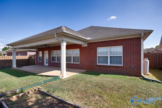 back of property with ceiling fan, a patio area, and a lawn