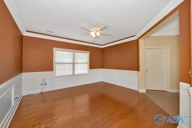 spare room featuring ceiling fan, ornamental molding, and light wood-type flooring