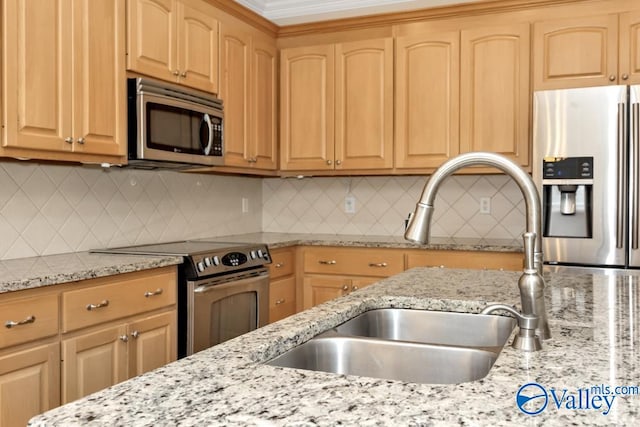 kitchen with appliances with stainless steel finishes, light brown cabinetry, sink, and backsplash