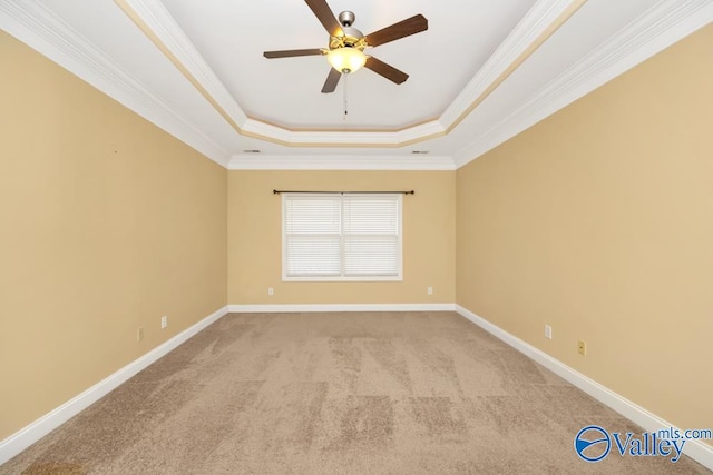 carpeted spare room with a tray ceiling, ceiling fan, and crown molding