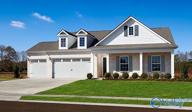 view of front facade with a garage, a front lawn, driveway, brick siding, and covered porch
