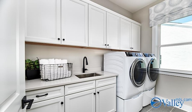 laundry room featuring separate washer and dryer, cabinet space, tile patterned floors, and baseboards