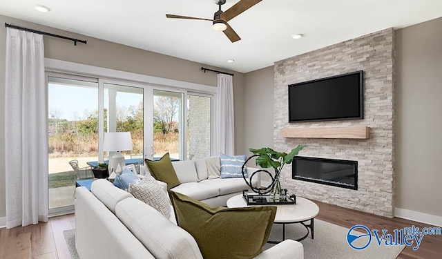 living room featuring ceiling fan, wood finished floors, a fireplace, baseboards, and recessed lighting