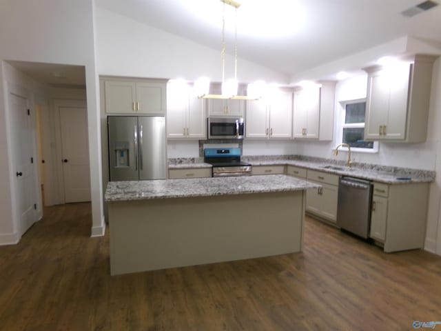 kitchen featuring a center island, dark hardwood / wood-style floors, light stone countertops, decorative light fixtures, and stainless steel appliances