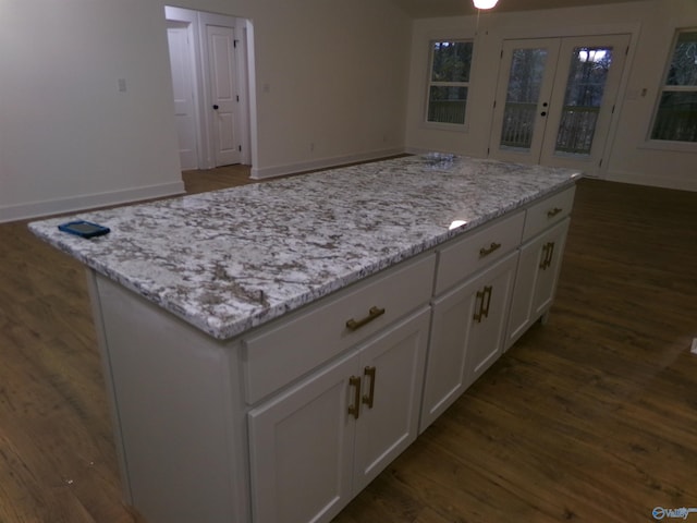 kitchen featuring white cabinets, dark hardwood / wood-style flooring, light stone counters, and french doors