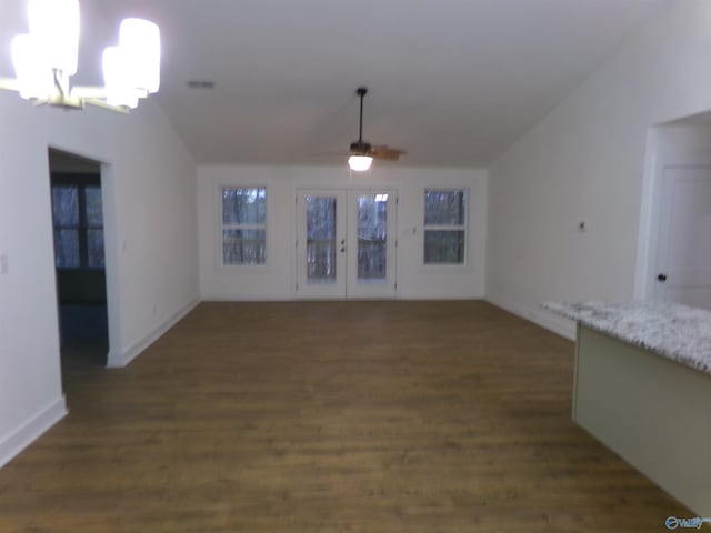 unfurnished living room with french doors, ceiling fan with notable chandelier, and dark wood-type flooring