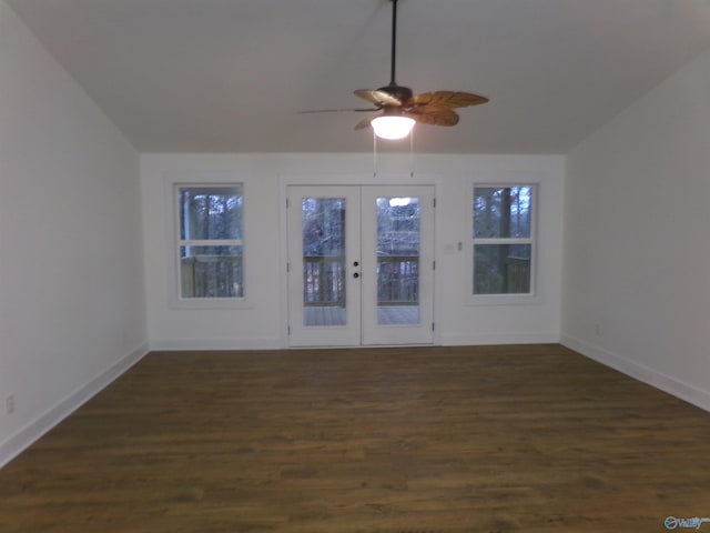 spare room featuring ceiling fan, a healthy amount of sunlight, dark wood-type flooring, and french doors