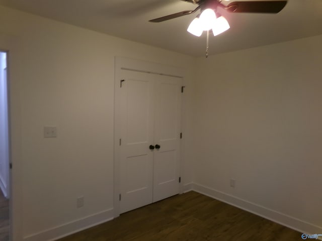 unfurnished bedroom with a closet, ceiling fan, and dark wood-type flooring