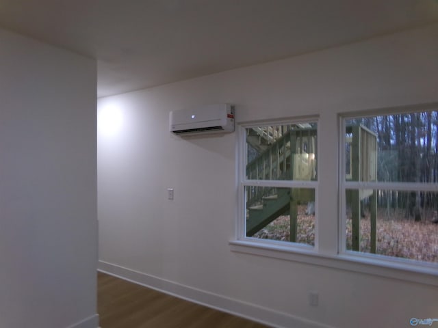 spare room with wood-type flooring and a wall mounted AC