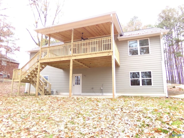 back of property with a wooden deck, ceiling fan, and a patio