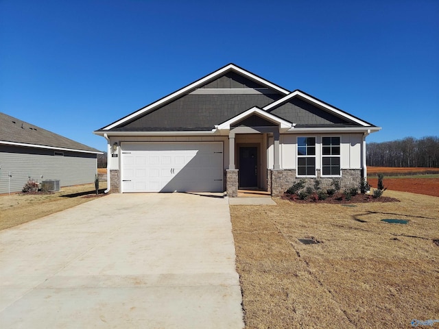 craftsman-style house with concrete driveway, stone siding, central AC, and a garage