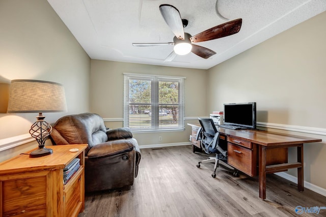 home office with ceiling fan, hardwood / wood-style flooring, and a textured ceiling