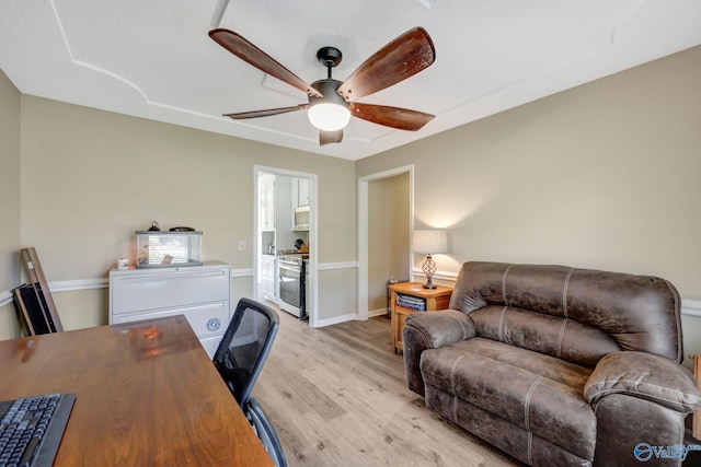 office featuring light wood-type flooring, a textured ceiling, and ceiling fan