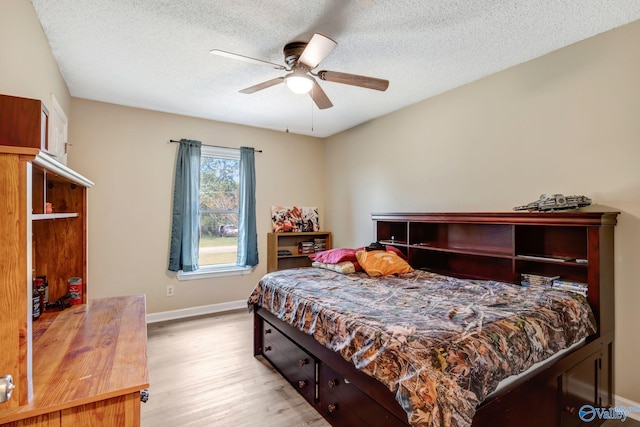 bedroom featuring light hardwood / wood-style floors, ceiling fan, and a textured ceiling