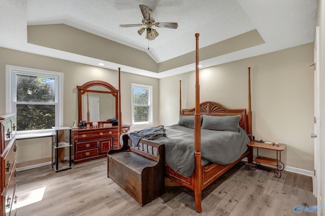 bedroom featuring ceiling fan, a textured ceiling, light wood-type flooring, and vaulted ceiling