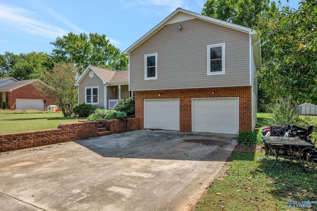 split level home featuring a garage and a front lawn