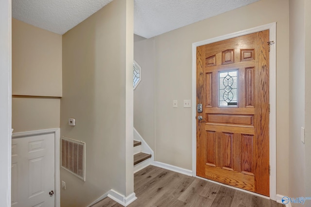 foyer with light hardwood / wood-style flooring and a textured ceiling