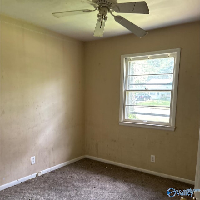 carpeted spare room featuring baseboards and ceiling fan
