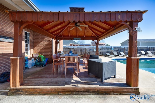 view of patio featuring a fenced in pool, a ceiling fan, fence, a deck, and a gazebo