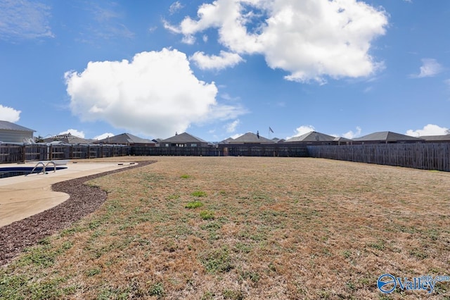 view of yard featuring a patio area, a fenced backyard, and a residential view