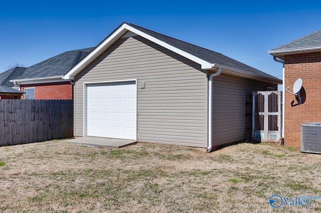 garage featuring central AC, fence, and driveway