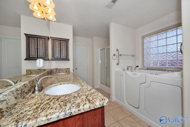 bathroom with tile patterned floors, washing machine and clothes dryer, vanity, and plus walk in shower