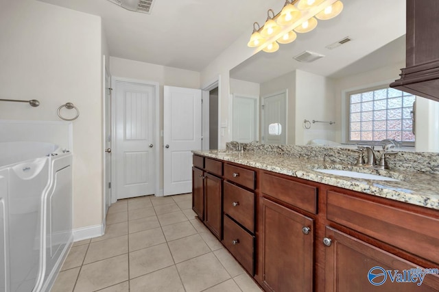 bathroom with tile patterned flooring, vanity, washer and dryer, and a bathing tub