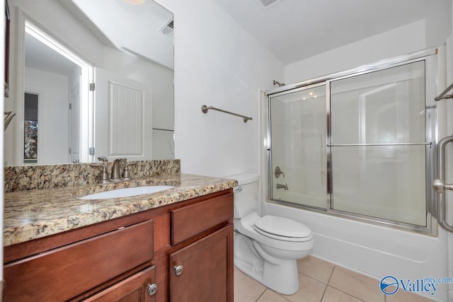 full bathroom featuring tile patterned flooring, vanity, toilet, and bath / shower combo with glass door