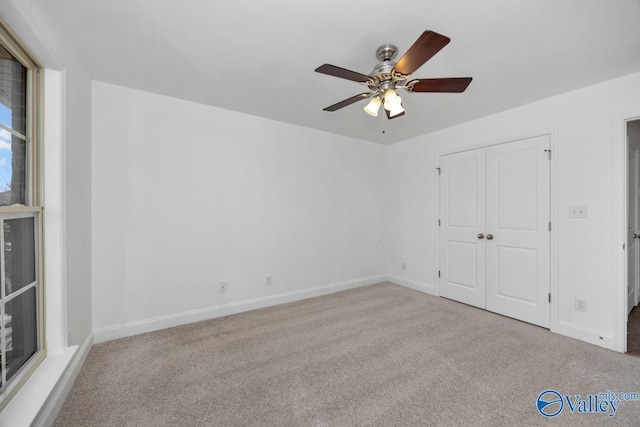 unfurnished bedroom featuring ceiling fan, light colored carpet, and a closet