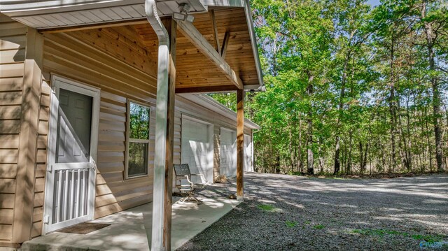 view of side of property featuring a patio and a garage