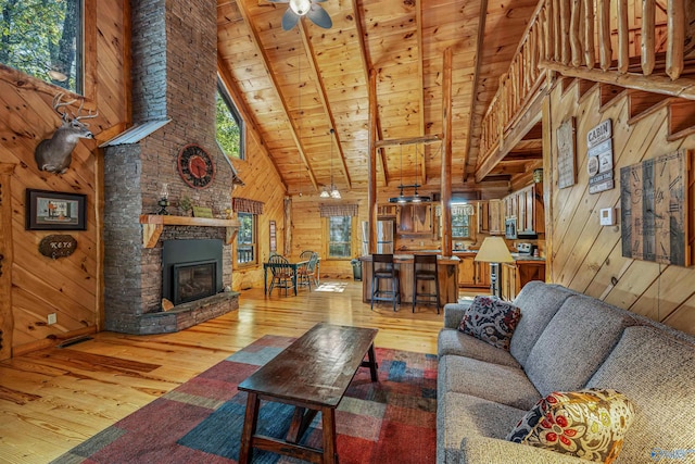 living room featuring beamed ceiling, wood ceiling, hardwood / wood-style floors, and wooden walls