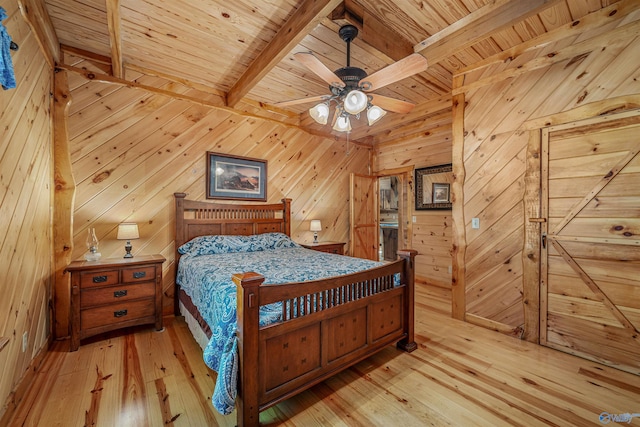 bedroom featuring beamed ceiling, wooden walls, light hardwood / wood-style flooring, wooden ceiling, and ceiling fan