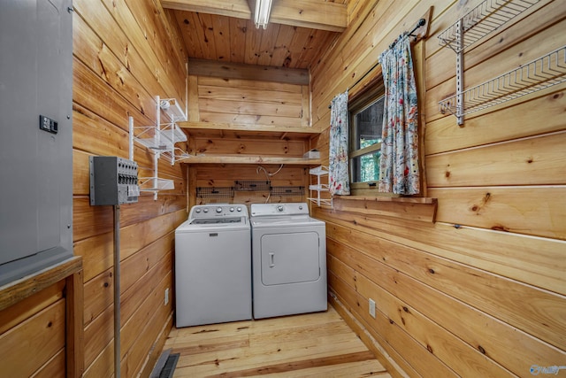 washroom with wooden ceiling, washer and dryer, light wood-type flooring, and wooden walls