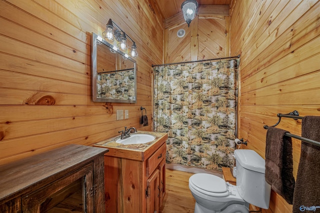 bathroom featuring vanity, toilet, curtained shower, and wooden walls