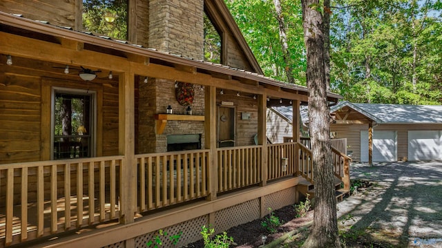 wooden terrace featuring an outdoor structure and a garage