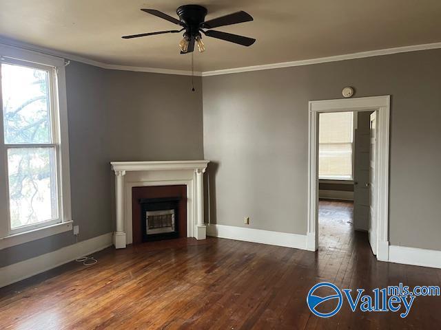 unfurnished living room featuring ceiling fan, dark hardwood / wood-style floors, and crown molding