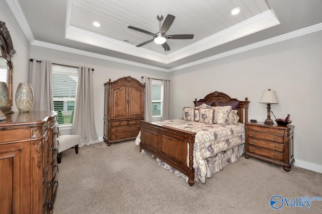 bedroom with light carpet, ornamental molding, a tray ceiling, and ceiling fan