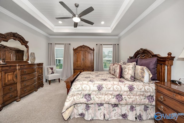 bedroom with ceiling fan, ornamental molding, a tray ceiling, and light colored carpet