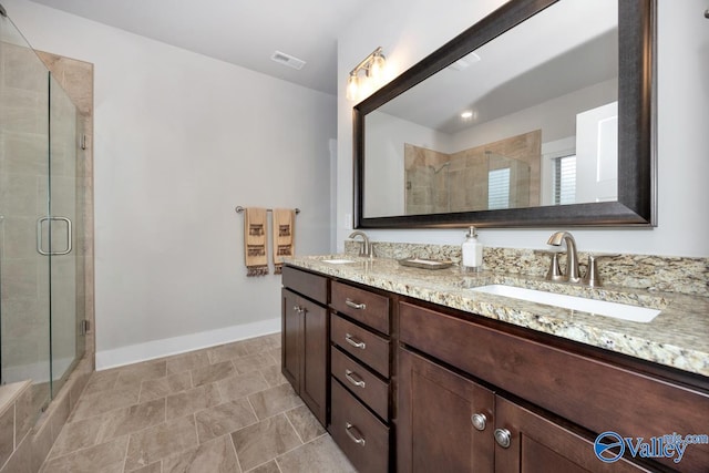 bathroom featuring a shower with door and vanity