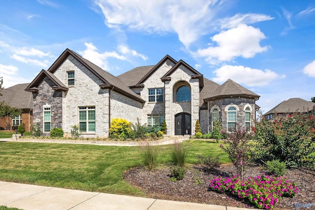 french country inspired facade featuring a front yard