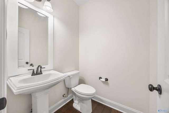 bathroom featuring hardwood / wood-style flooring and toilet