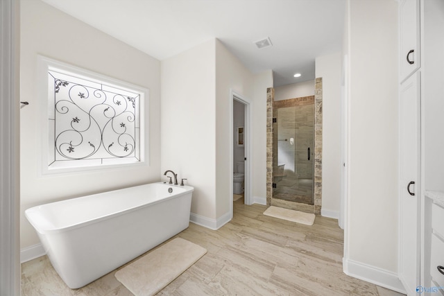 bathroom with wood-type flooring, toilet, and plus walk in shower