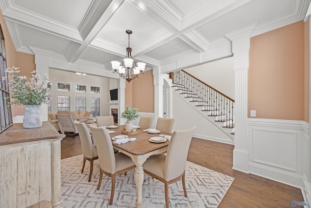 dining room with a notable chandelier, coffered ceiling, beamed ceiling, and hardwood / wood-style flooring