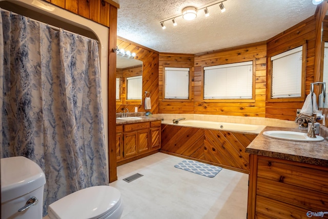 bathroom with toilet, wooden walls, a textured ceiling, vanity, and a bath