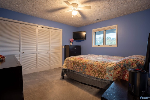 bedroom featuring carpet flooring, a textured ceiling, ceiling fan, and a closet