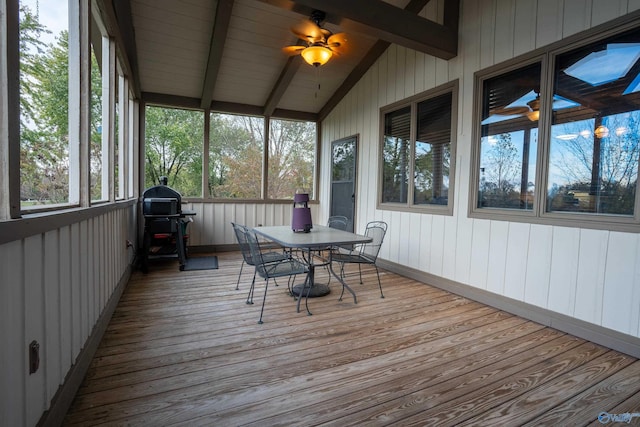 unfurnished sunroom with ceiling fan and lofted ceiling with beams