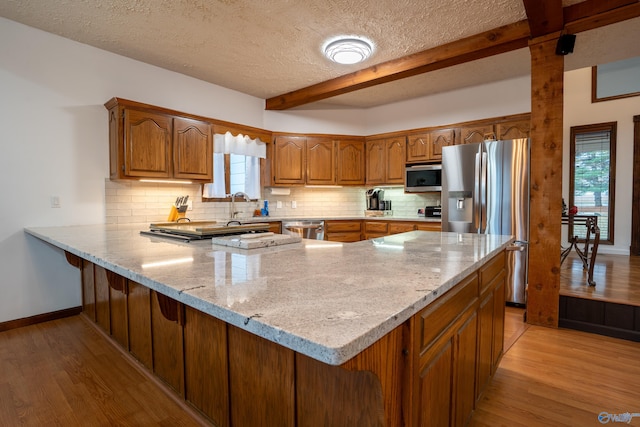 kitchen featuring kitchen peninsula, stainless steel appliances, and a wealth of natural light